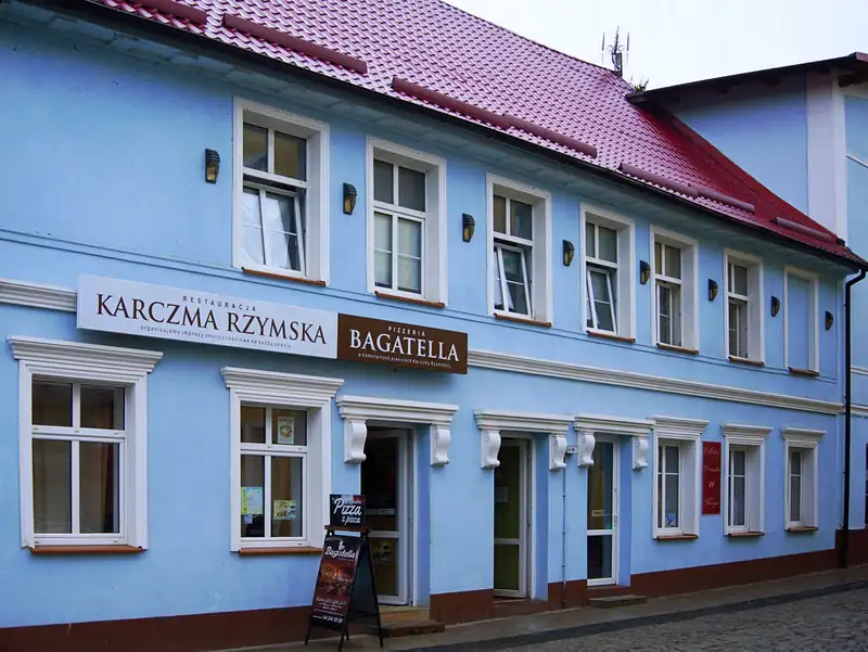 Niebieska kamienica z szyldami Karczma Rzymska i Bagatella