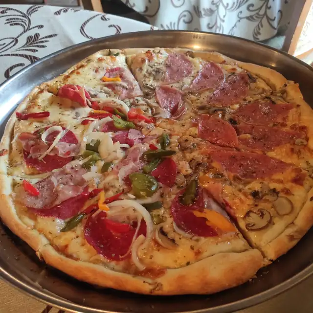 Pizza Bagatella z szynką, salami, pomidorem i cebulą na metalowej tacy