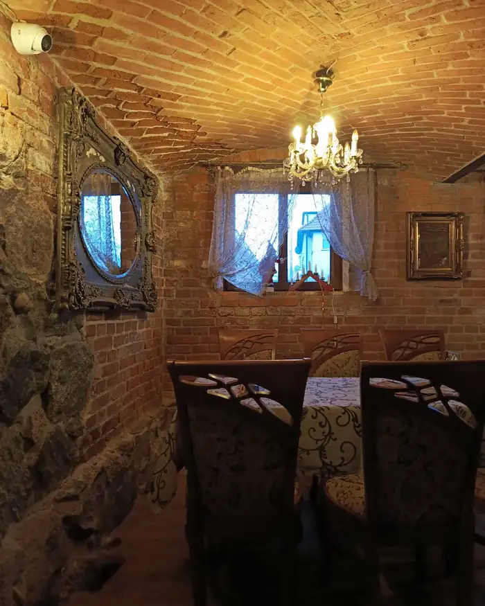 Sala pod łukowym sklepieniem z cegły z żyrandolem i oknem